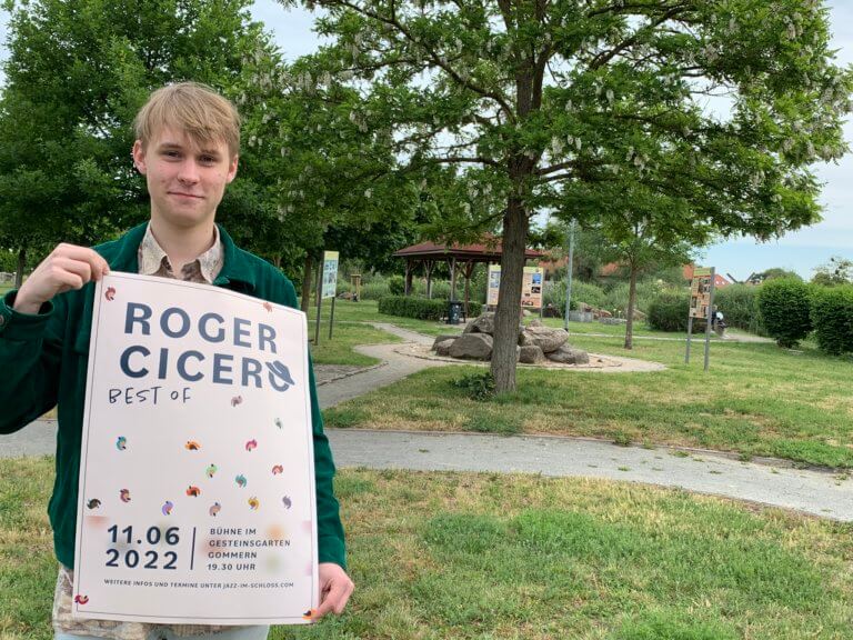Niclas Rotermund präsentiert das Plakat für die Veranstaltung.
